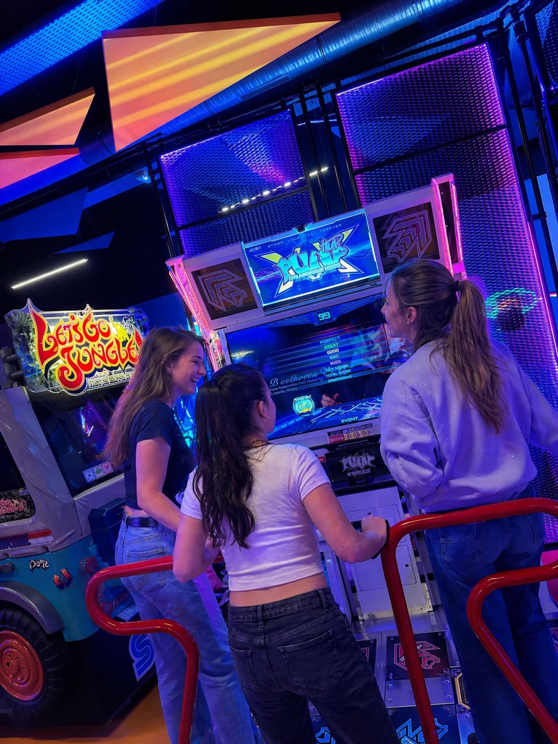 Trois amies devant la borne Pump It Up - Game Joy